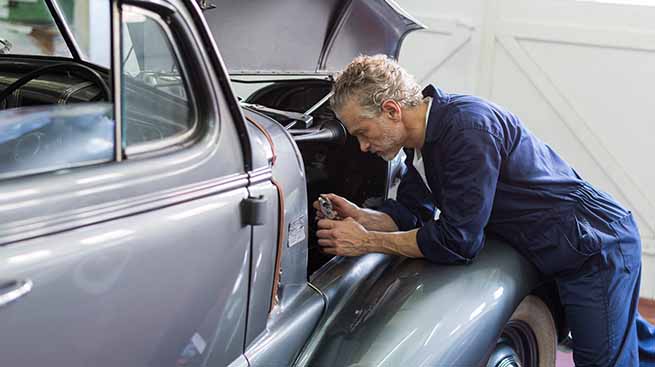 man working on classic car